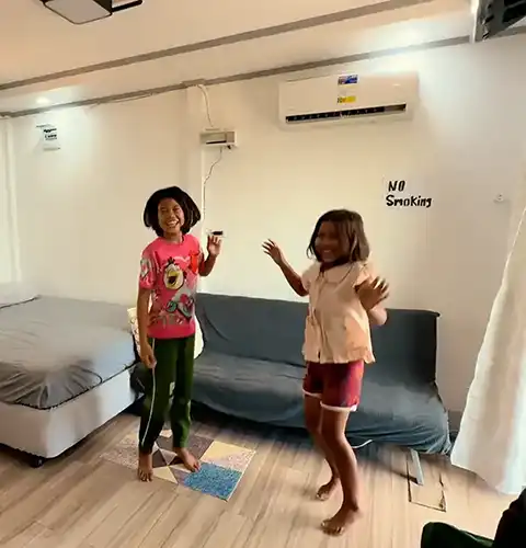 Kids happily playing inside a cozy guesthouse room on Olango Island